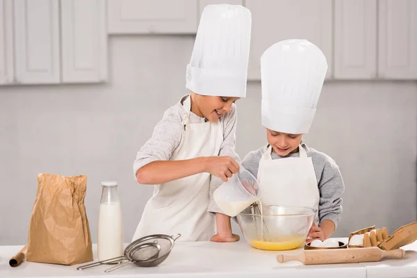 Boy Pouring Milk Bowl While Sister Standing Table Kitchen — Stock Photo, Image