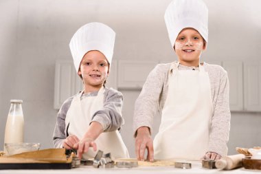 mutlu çocuk chef şapka ve önlük hamur mutfak masasında tanımlama bilgileri için kesmek