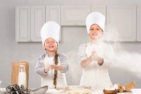 Szczęśliwy Dzieci Kapeluszach Chef Zabawy Mąki Kuchni — Zdjęcie stockowe