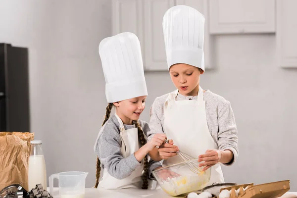 Niños Pequeños Con Gorros Chef Delantales Batiendo Huevos Tazón Mesa — Foto de Stock