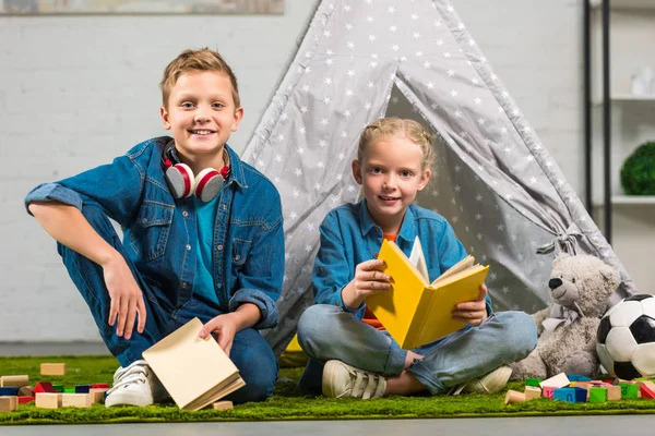 Glada Barn Med Böcker Tittar Kameran Nära Tältet Hemma — Stockfoto