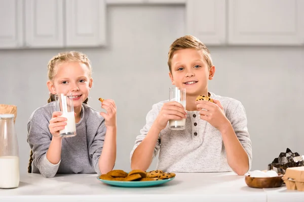 Glada Barn Äta Kakor Och Dricka Mjölk Bordet Köket — Stockfoto