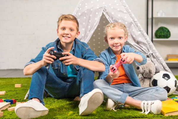 Alegre Hermana Hermano Jugando Con Joysticks Cerca Wigwam Casa — Foto de Stock