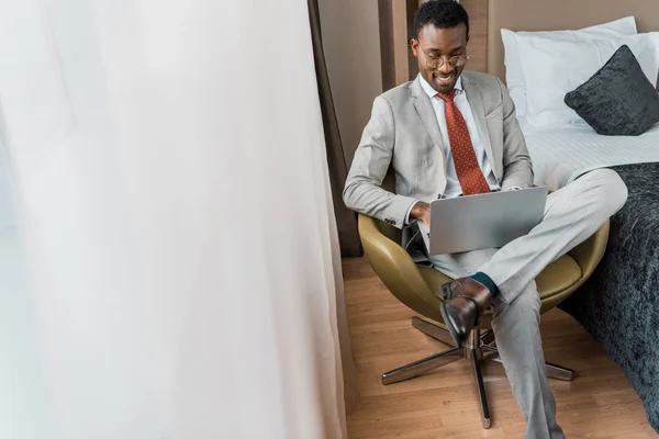 Sonriente Hombre Negocios Afroamericano Traje Trabajo Ordenador Portátil Habitación Hotel — Foto de Stock