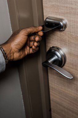 Kırpılan görünümünü Afrika kökenli Amerikalı adam otel elektronik anahtar kart ile kapı açma