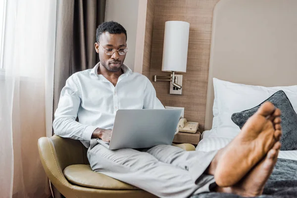 Young Barefoot African American Businessman Using Laptop Hotel Room — Stock Photo, Image