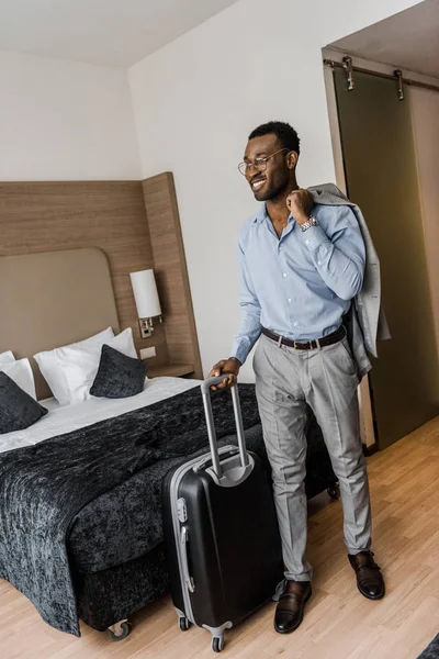 Szczęśliwy Afryki Amerykański Biznesmen Torba Podróżna Pokoju Hotelowym — Darmowe zdjęcie stockowe