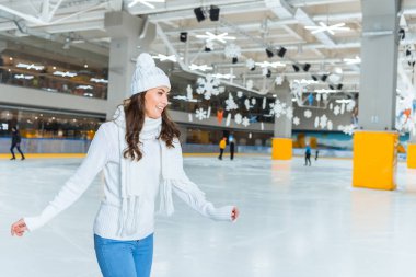 örme kazak buz pistinde yalnız paten genç çekici kadın gülümseyerek