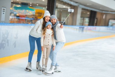buz pateni pisti smartphone üzerinde gülümseyen aile alarak selfie