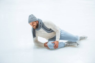 man injured knee while skated on ice rink clipart