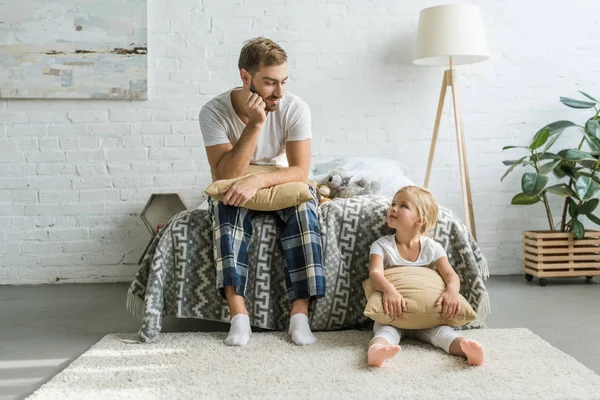 Padre Pijama Sentado Cama Mirando Linda Hija Pequeña Sentada Con — Foto de Stock