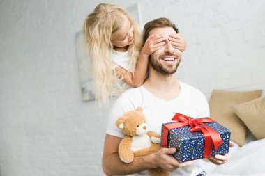 sevimli küçük kızını gözleri mutlu baba hediye kutusu ve oyuncak ayı tutarak kapanış 