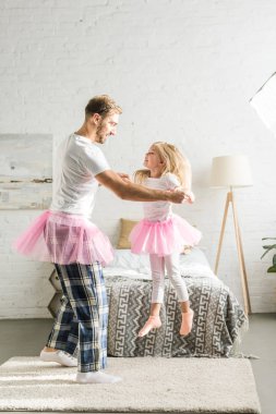 mutlu baba ve sevimli küçük kız evde dans pembe tutu etek içinde 