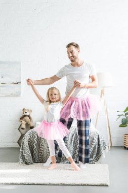 mutlu baba ve kız elele ve birlikte evde dans pembe tutu etek