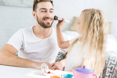 sevimli küçük kızını evde baba sakallı mutlu makyaj uygulamak