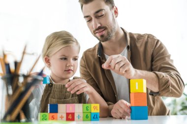 küçük kızı matematik açıklayan ve renkli küpleri ile evde oynarken babası