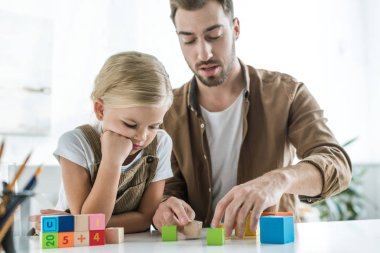 Baba ve renkli küpler evde sıkılmış küçük kızı öğrenme matematik