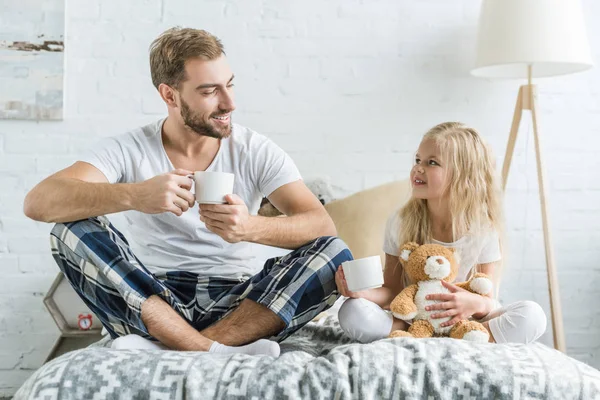 Happy Father Daughter Holding Tea Cups Smiling Each Other Bed — Stock Photo, Image
