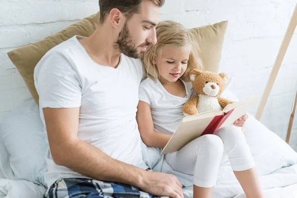 Отец Очаровательная Маленькая Дочь Читают Книгу Вместе Кровати — стоковое фото