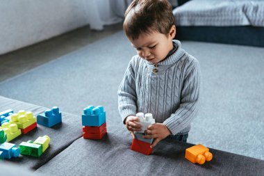 renkli plastik blokları ile evde oynarken rahatsız küçük çocuk