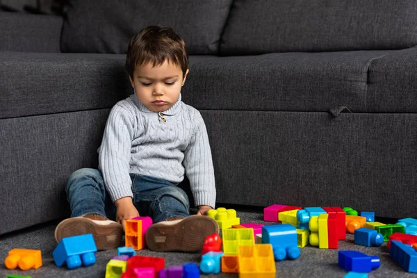 Маленький Мальчик Играет Красочными Пластиковыми Блоками Дома — стоковое фото