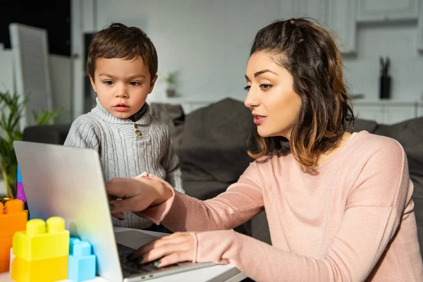 Attractive Woman Pointing Laptop Screen Her Little Son Home — Stock Photo, Image