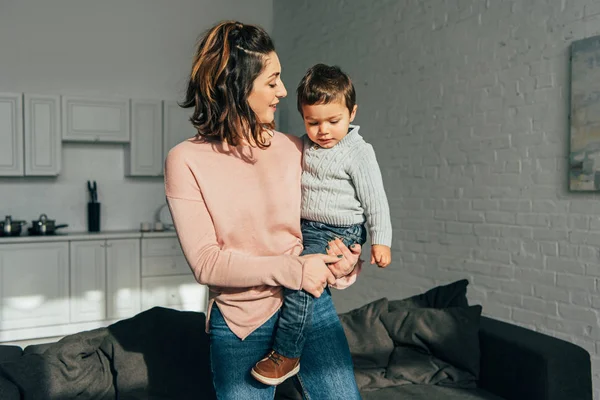 Hermosa Mujer Sosteniendo Adorable Niño Las Manos Casa — Foto de stock gratis