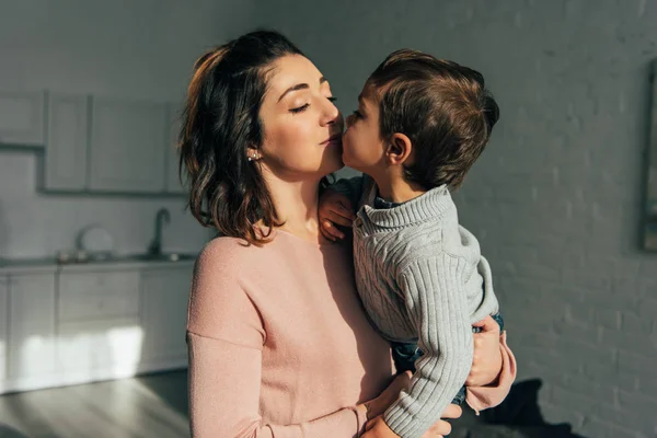 Kis Fiú Kissing Anya Míg Tartja Kezét Otthon — Stock Fotó