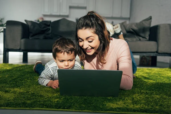 Mãe Feliz Pequeno Filho Deitado Chão Com Laptop Casa — Fotografia de Stock