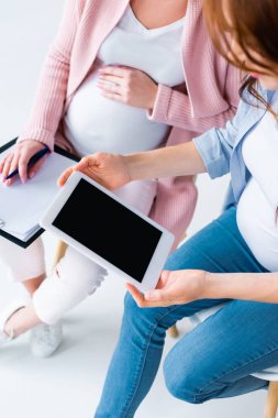 iki hamile kadın Doğum öncesi sınıf sırasında dijital tablet kullanarak görünümünü kırpılmış