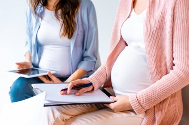 Dijital tablet ve formlarda Doğum öncesi sınıfı gri izole sırasında yazma hamile kadınlar