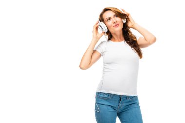 güzel kadın müzik dinleme gülümseyen ve kulaklık üzerinde beyaz izole iki eliyle tutarak