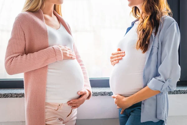 Vista Recortada Mujeres Embarazadas Sonrientes Pie Junto Ventana — Foto de Stock