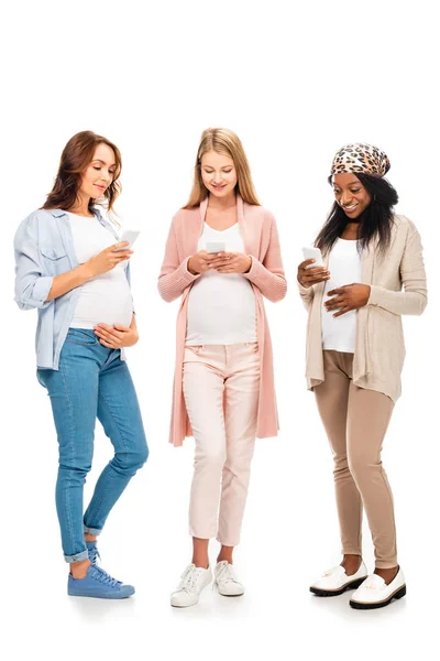 Lachende Multiculturele Zwangere Vrouwen Met Behulp Van Smartphones Geïsoleerd Wit — Stockfoto