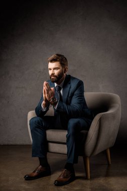 yakışıklı işadamı eller dua ile koltuk oturma
