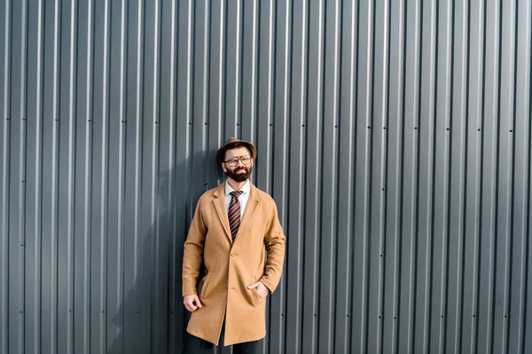 Guapo Hombre Negocios Abrigo Pie Contra Sol Cerca Pared Texturizada — Foto de stock gratis