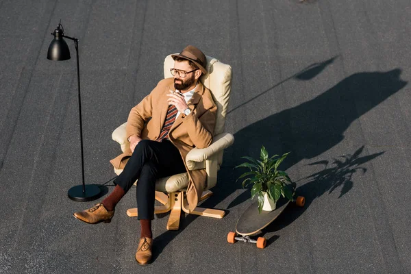 Hombre Negocios Sentado Sillón Con Cigarrillo Cerca Lámpara Penny Board — Foto de Stock