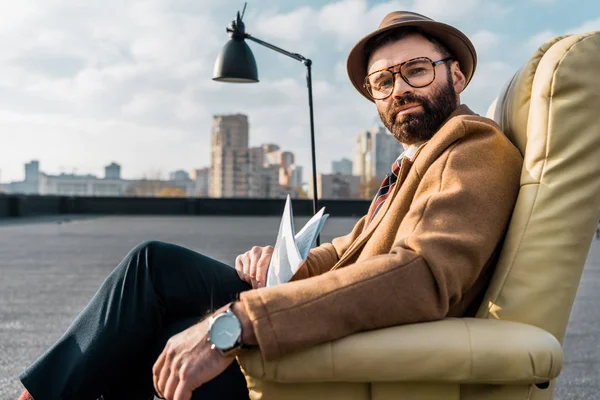 Adult Säker Affärsman Som Sitter Fåtölj Med Tidningen Nära Lampa — Stockfoto