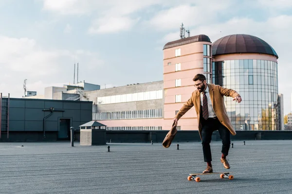 Vousatý Podnikatel Jízda Penny Board Taškou Ruce — Stock fotografie zdarma