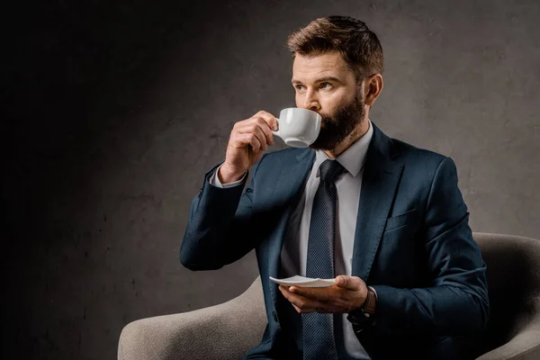 Selbstbewusster Geschäftsmann Der Kaffee Trinkt Und Untertasse Hält — kostenloses Stockfoto