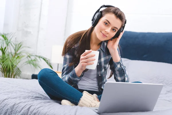 Beautiful Smiling Girl Headphones Holding Cup Using Laptop Bed — Stock Photo, Image