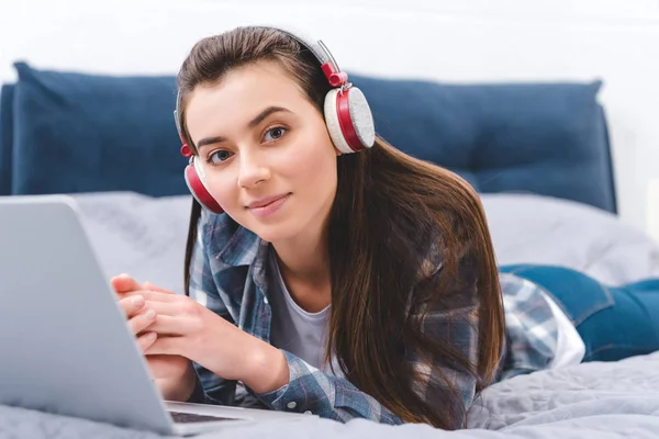 Beautiful Girl Headphones Using Laptop Bed Smiling Camera — Free Stock Photo