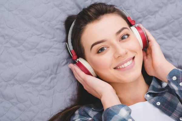 Attraente Giovane Donna Cuffia Sdraiata Sul Letto Sorridente Alla Fotocamera — Foto Stock