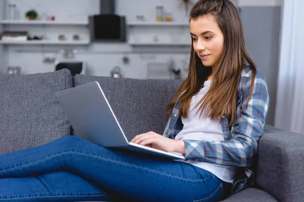 Sorrindo Jovem Mulher Sentada Sofá Usando Laptop — Fotografia de Stock