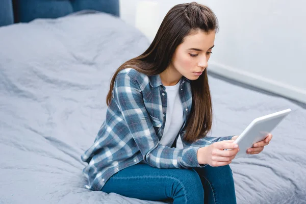 年轻女子坐在床上使用数字平板电脑的高角度视角 — 图库照片