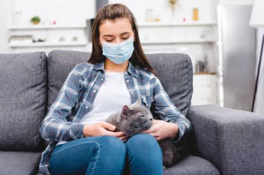 kedi tutarak ve anti evde acı tıbbi maske kız  