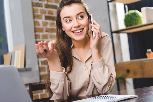 Genç Kadını Ofiste Çalışırken Smartphone Ile Konuşurken Gülümseyen — Ücretsiz Stok Fotoğraf