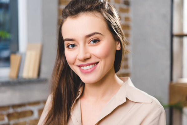 Портрет красивой молодой предпринимательницы, улыбающейся в камеру
