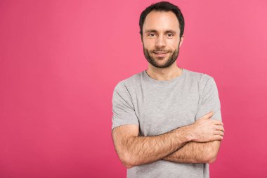 handsome smiling man posing with crossed arms, isolated on pink clipart