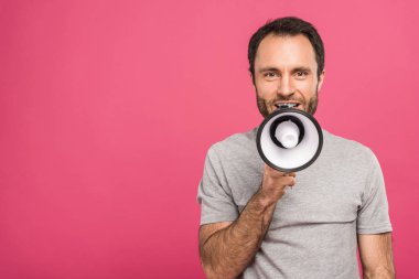 happy handsome man speaking with megaphone, isolated on pink clipart